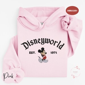 A pink hoodie with the text "Disneyworld" and a Mickey Mouse graphic printed on it.