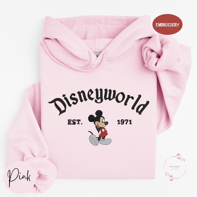 A pink hoodie with the text "Disneyworld" and a Mickey Mouse graphic printed on it.