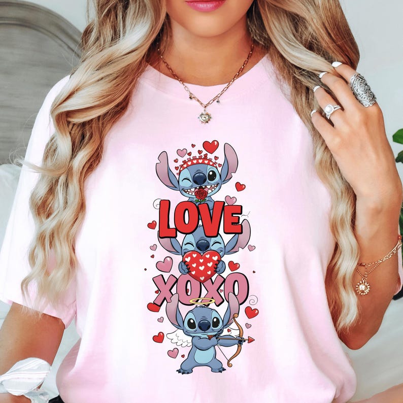 A woman wearing a pink t-shirt with a graphic design featuring a cartoon character and the text "LOVE XO XO" surrounded by hearts.