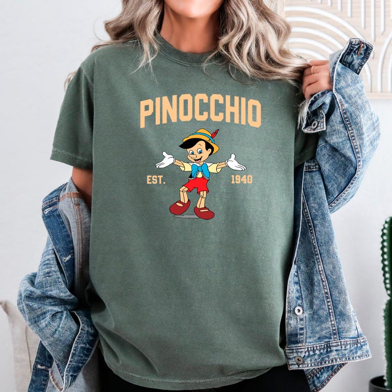 May include: A green t-shirt with a cartoon image of Pinocchio, the text "PINOCCHIO", "EST. 1940", and a yellow and orange color scheme.