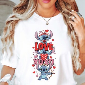 A woman wearing a white t-shirt with a graphic design featuring a cartoon character and the text "LOVE XOXO" surrounded by hearts.