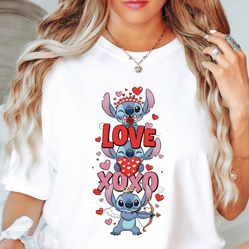 A woman wearing a white t-shirt with a graphic design featuring a cartoon character and the text "LOVE XOXO" surrounded by hearts.
