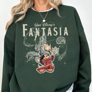 A green sweatshirt with a Disney-themed graphic of Mickey Mouse and a castle, along with the text "Disney's Fantaasia".