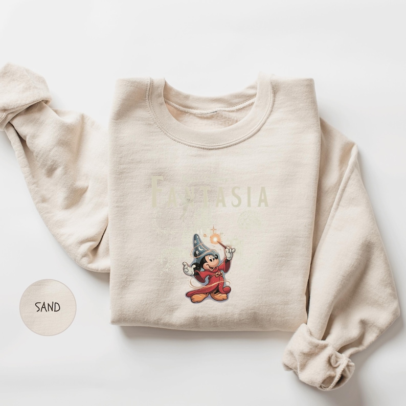 A beige sweater with a Disney character printed on it, along with the text "FANTASIA" printed below the character.