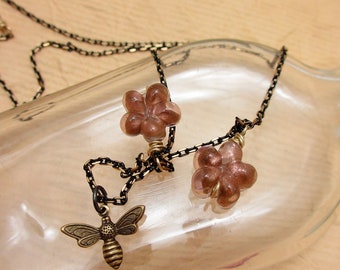 SALE. Bees in the Flowers. Brass bee charm with glass flowers on black two-tone chain