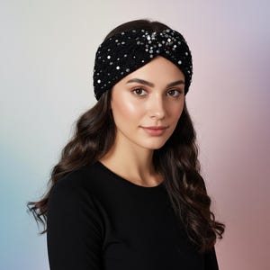 May include: A black sequined headband with a twisted knot design. The headband is decorated with silver sequins, adding a touch of sparkle. The accessory is worn on the head, and is a stylish hair accessory.