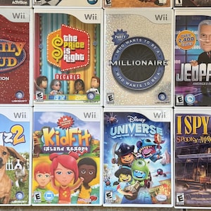 May include: Collection of Wii video game cases featuring titles like "Family Feud," "The Price is Right," "Millionaire," and "Jeopardy!" The game covers display colorful graphics and character illustrations, showcasing various game themes.