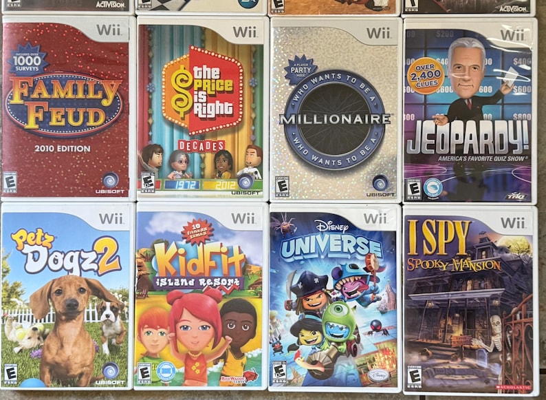 May include: Collection of Wii video game cases featuring titles like "Family Feud," "The Price is Right," "Millionaire," and "Jeopardy!" The game covers display colorful graphics and character illustrations, showcasing various game themes.
