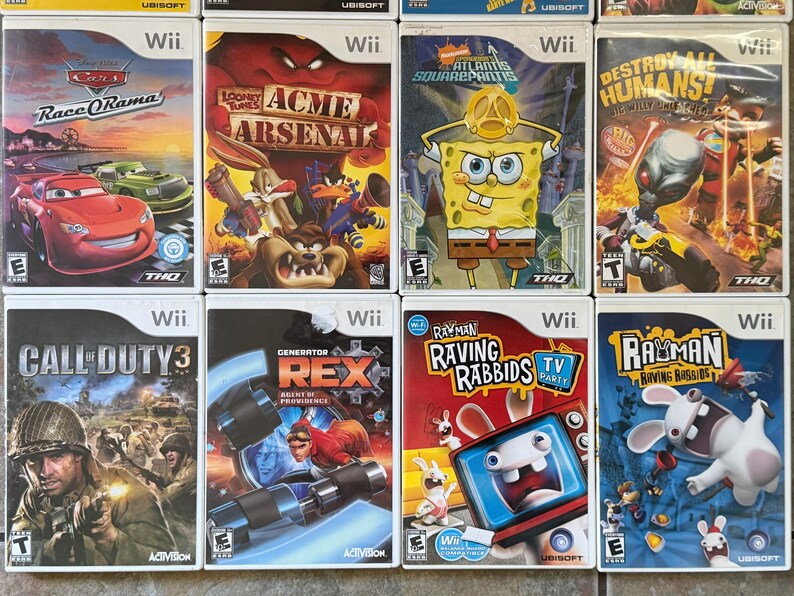 May include: A collection of Wii video game cases. Titles include "Cars: Race-O-Rama", "Looney Tunes: Acme Arsenal", "SpongeBob SquarePants: Atlantis SquarePantis", and "Destroy All Humans!"