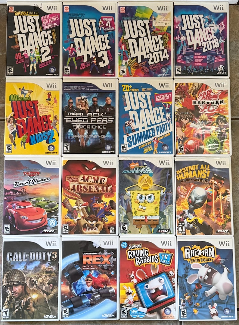 May include: A collection of Wii video game cases, including titles like "Just Dance 2," "Just Dance 3," and "Call of Duty 3." The cases feature colorful graphics and game titles. The games are from various genres.