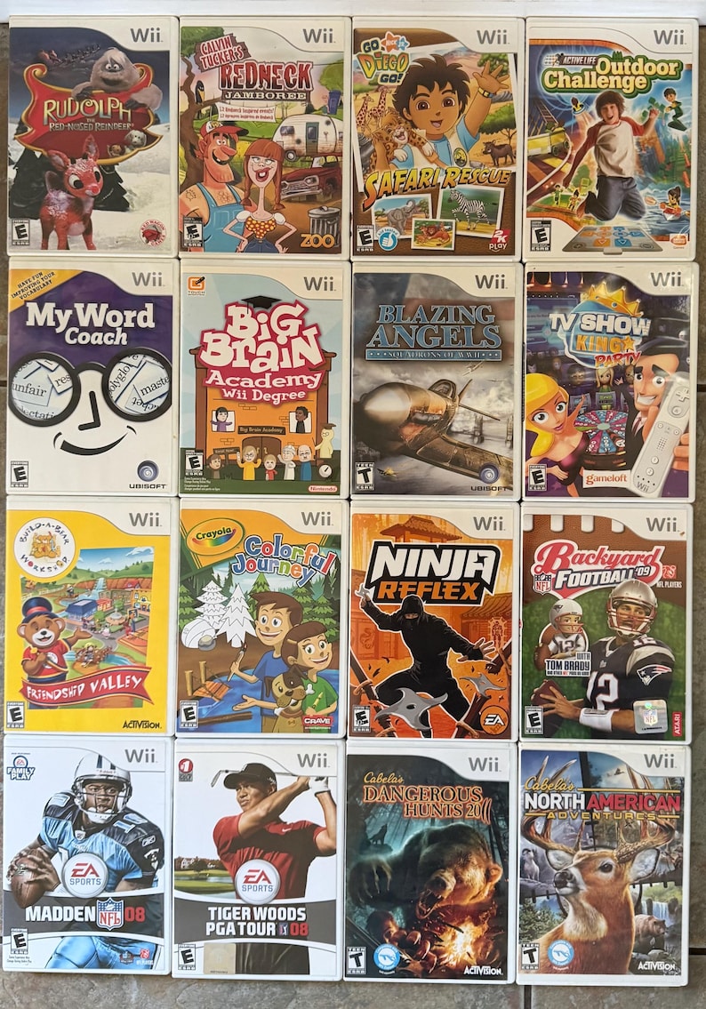 May include: A collection of Wii video game cases. Titles include "Rudolph," "Calvin Tucker's Redneck Jamboree," "Go Diego Go! Safari Rescue," and "Outdoor Challenge." Other games are "My Word Coach," "Big Brain Academy," and "Blazing Angels."