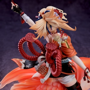 May include: A detailed figurine of a character from the video game Genshin Impact. The character is a young woman with long, flowing blonde hair, wearing a red and orange outfit with a fishtail. She is holding a red and white staff in her right hand. The figurine is made of high-quality materials and is very detailed.