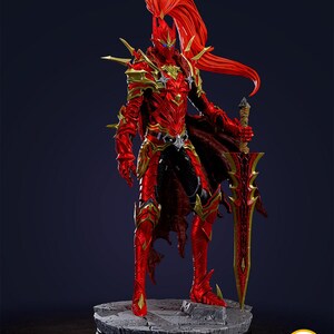 May include: A detailed figurine of a warrior in red and gold armor, holding a large sword. The figure has a flowing red hair and is standing on a stone base. The text "PATREON.COM/BEEFIGURES" is visible.