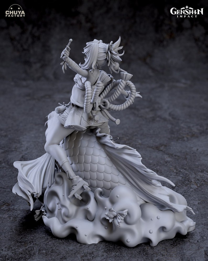 May include: Gray painted figurine of a female character from the video game Genshin Impact. The character is holding a staff and is riding a large fish. The base of the figurine is a cloud-like shape with a small fish.
