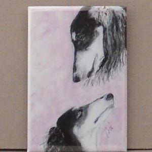 May include: A black and white painting of two dogs looking at each other. The dogs are on a pink background. The painting is on a white canvas.