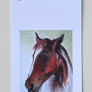 May include: A watercolor painting of a brown horse's head with a white star on its forehead. The horse is looking to the left of the image.