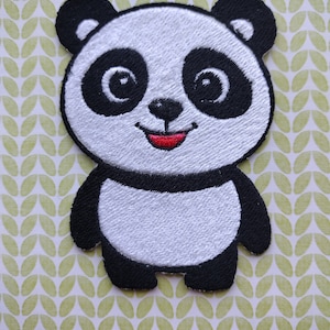 May include: Embroidered panda bear patch with black and white fur, black eyes, and a red smiling mouth. The patch is on a green and white patterned background.