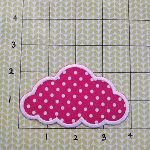 May include: A pink cloud-shaped fabric patch with white polka dots and a white stitched border.