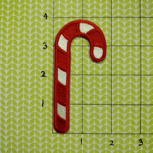 May include: Red and white candy cane Christmas ornament patch. The patch is about 3 inches tall and 1 inch wide.