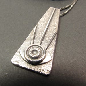 Trapezoid pendant in argentium sterling silver featuring the all seeing eye, sleek and modern with an art deco vibe. apx. 2" long x .75" wide. Oxidized and polished finished with 18" SS box chain and handmade argentium findings.