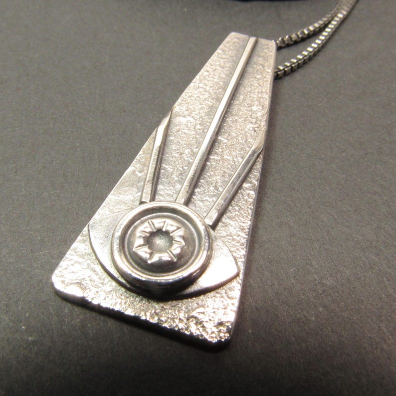Trapezoid pendant in argentium sterling silver featuring the all seeing eye, sleek and modern with an art deco vibe. apx. 2" long x .75" wide. Oxidized and polished finished with 18" SS box chain and handmade argentium findings.
