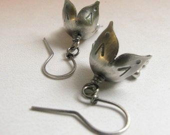May include: A pair of silver earrings with a flower design. The earrings are made of metal and have a delicate, feminine look.