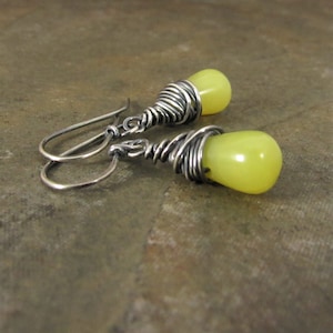 Little jots of color from these citrusy serpentine drops wrapped with a generous wrapping of sterling silver wire darkened with oxidation and polished for a wonderful contrast against the serpentine.  Lovely yellow green chartreuse  color

1.25 long