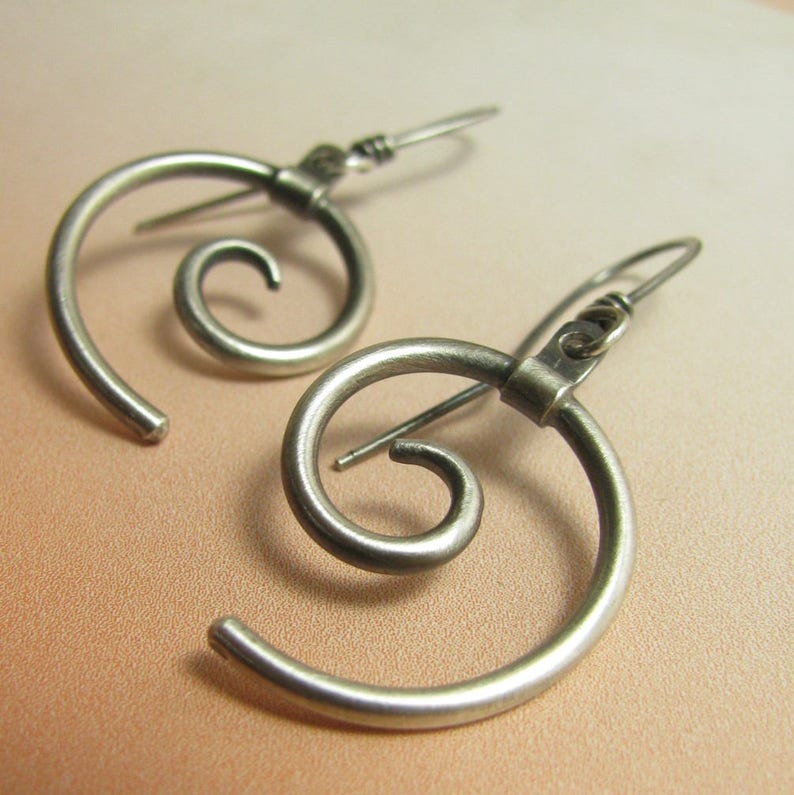 Spiral earrings crafted from argentium sterling silver are thoroughly modern but timeless. The spiral is the most fundamental pattern in nature.  Oxidized and polished to finish Lightweight

1.75 inch tall
.75 inch wide