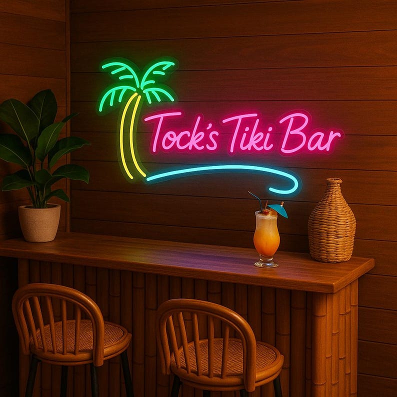 May include: A neon sign for "Tock's Tiki Bar" with a palm tree design. The sign is in green, yellow, pink, and blue, mounted on a wood-paneled wall. A cocktail sits on the bar, with two wicker chairs in front.
