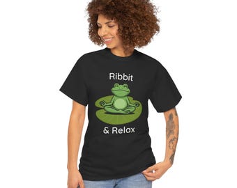 May include: Black t-shirt featuring a cartoon frog meditating on a lily pad. The frog is green, and the lily pad is green. The text "Ribbit & Relax" is above and below the frog.