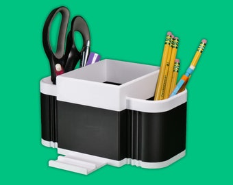 May include: Black and white desk organizer with four compartments. The organizer has a compartment for pens and pencils, a compartment for scissors, and two other compartments. The organizer is filled with yellow pencils, a pair of black scissors, and a purple pen.