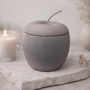 May include: A set of three ceramic mugs with a speckled, matte finish. The mugs are in shades of cream, light gray, and dark gray. Each mug has a simple, minimalist design, perfect for coffee or tea.