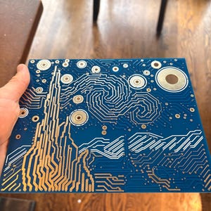 Puede incluir: Una placa de circuito impreso cuadrada de color azul con un patr&oacute;n de pistas conductoras de color cobre que replica el cielo arremolinado y el paisaje de una pintura famosa, con puntos de contacto met&aacute;licos circulares.