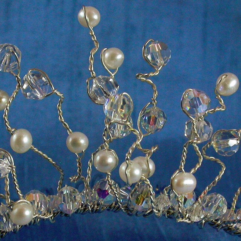 Puede incluir: Un peine para el cabello de alambre plateado con cuentas de cristal transparentes y cuentas de perla blancas. El peine est&aacute; dise&ntilde;ado en un estilo en cascada con las cuentas colgando del alambre.