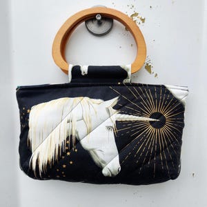Cartera acolchada con asas de madera y diseño de unicornios