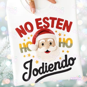 May include: White sweatshirt with a Santa Claus design. The design includes the text "NO ESTEN HO Jodiendo" in red and black, with a Santa face and yellow stars. The sweatshirt is a festive holiday item.
