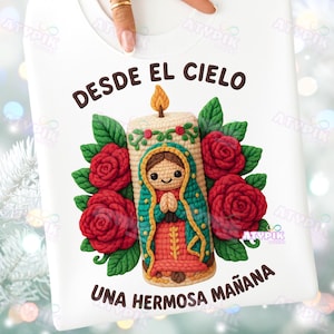 May include: White sweatshirt featuring a colorful graphic of a candle with a religious figure, surrounded by red roses and green leaves. The text "DESDE EL CIELO UNA HERMOSA MAÑANA" is printed above and below the graphic.