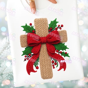 May include: White sweatshirt featuring a knitted cross design. The cross is adorned with a red bow, green holly leaves, and red berries. The design has the text "ATYPIK" in the lower right corner.