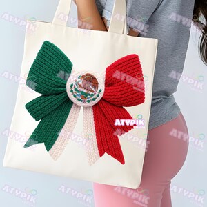 May include: A white tote bag with a large bow design in the colours of the Mexican flag: green, white, and red. The bow has a central emblem with the Mexican coat of arms. The bag has a simple design with sturdy handles.