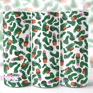 May include: A white tumbler featuring a repeating pattern of green cactus illustrations with pink flowers and brown pots. The design includes various cactus shapes and sizes, creating a playful and unique aesthetic. The tumbler has a silver straw.