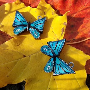 Turquoise polymer clay butterfly earrings with white and black details