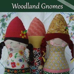 Pode incluir: Três bonecas gnomo feitas à mão com diferentes padrões de tecido. Os gnomos usam chapéus vermelhos, marrons e amarelos. As bonecas estão sentadas em um fundo de tecido branco. O texto "Woodland Gnomes" está no topo da imagem. O texto "Patchwork Posse Learn. Create. Share." está na parte inferior da imagem.