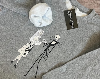 ジャックとサリーの刺繍入りスウェットシャツ - ギルダンクルーネック、心地よいハロウィンゴシックラブグラフィック、ナイトメア風プルオーバー