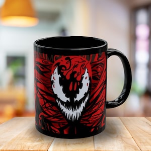 May include: Black ceramic coffee mug with a red and black graphic of a cartoon character with a large mouth and sharp teeth. The character is surrounded by red and black lines.