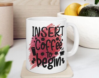 May include: White ceramic coffee mug with a red watercolor background and black text that reads "Insert Coffee to Begin".