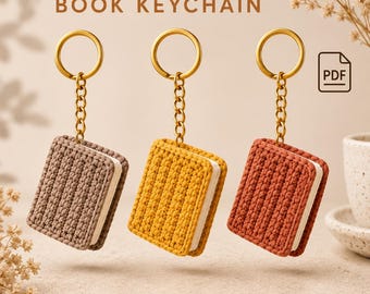 Puede incluir: Tres llaveros de libro tejidos a ganchillo en marrón, amarillo y terracota, cada uno con una anilla y cadena de metal dorado. El texto CROCHET BOOK KEYCHAIN aparece en la parte superior, junto a un icono PDF de archivo digital.