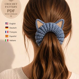 Könnte beinhalten: Ein blaues Häkel-Haaraccessoire mit zwei spitzen Katzenohren und beigen Innendetails. Der Text auf dem Bild lautet CROCHET PATTERN PDF INSTANT DOWNLOAD, zusammen mit einer Liste von Sprachen, darunter English, Deutsch, Français, Español und Italiano.