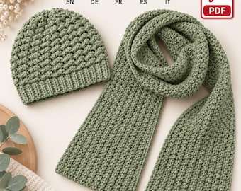 Puede incluir: Un gorro de ganchillo color verde salvia y una bufanda larga a juego. Ambos artículos presentan un patrón de puntos texturizados consistente. El gorro tiene un borde acanalado, mientras que la bufanda es rectangular y uniforme.