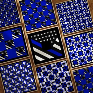 May include: Nine framed square art prints with various geometric patterns in blue, black, and white. Designs include stars, diamonds, and abstract shapes. The frames are a natural wood color, and the prints are arranged on a wooden surface.