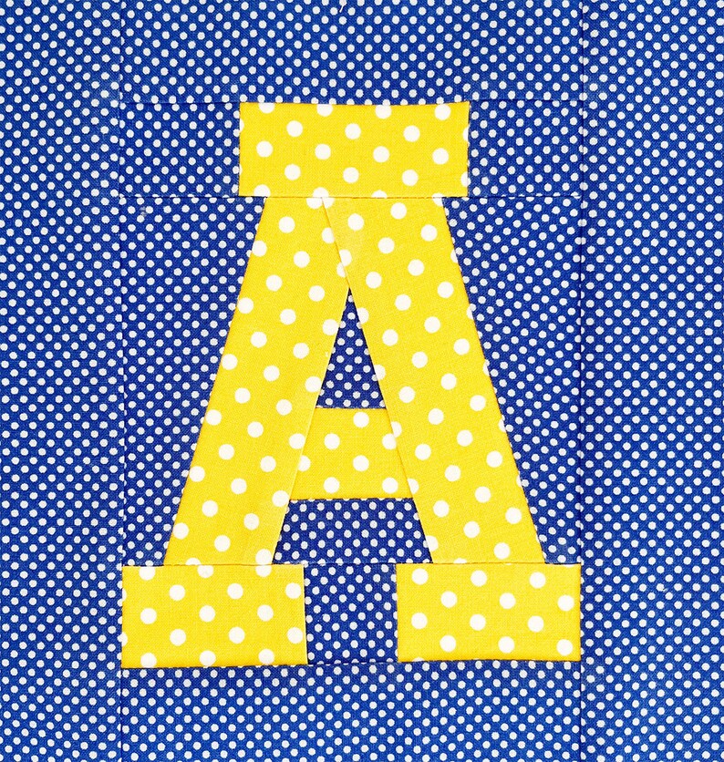 May include: A yellow letter A with white polka dots on a blue background with white polka dots.